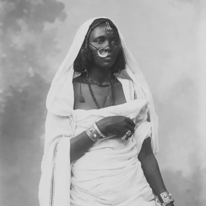 Portr&auml;t einer afrikanischen Frau in traditioneller Tracht, die dekorativen Schmuck tr&auml;gt.